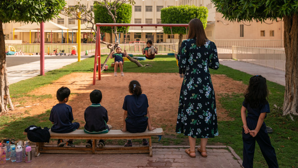 Students playing on playground, teacher watching WellSpring Private School jobs