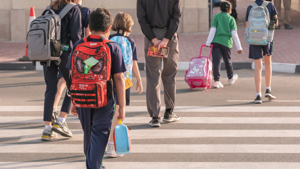 Students and teacher in cross walk on arrival at WellSpring Private School admissions